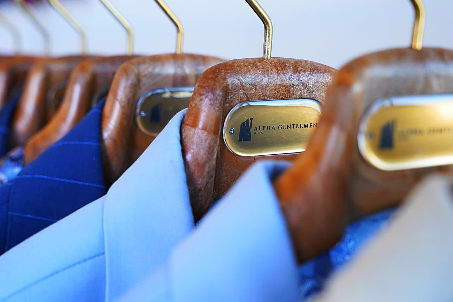 Alpha Gentlemen Suits jackets on branded gold-plate hangers