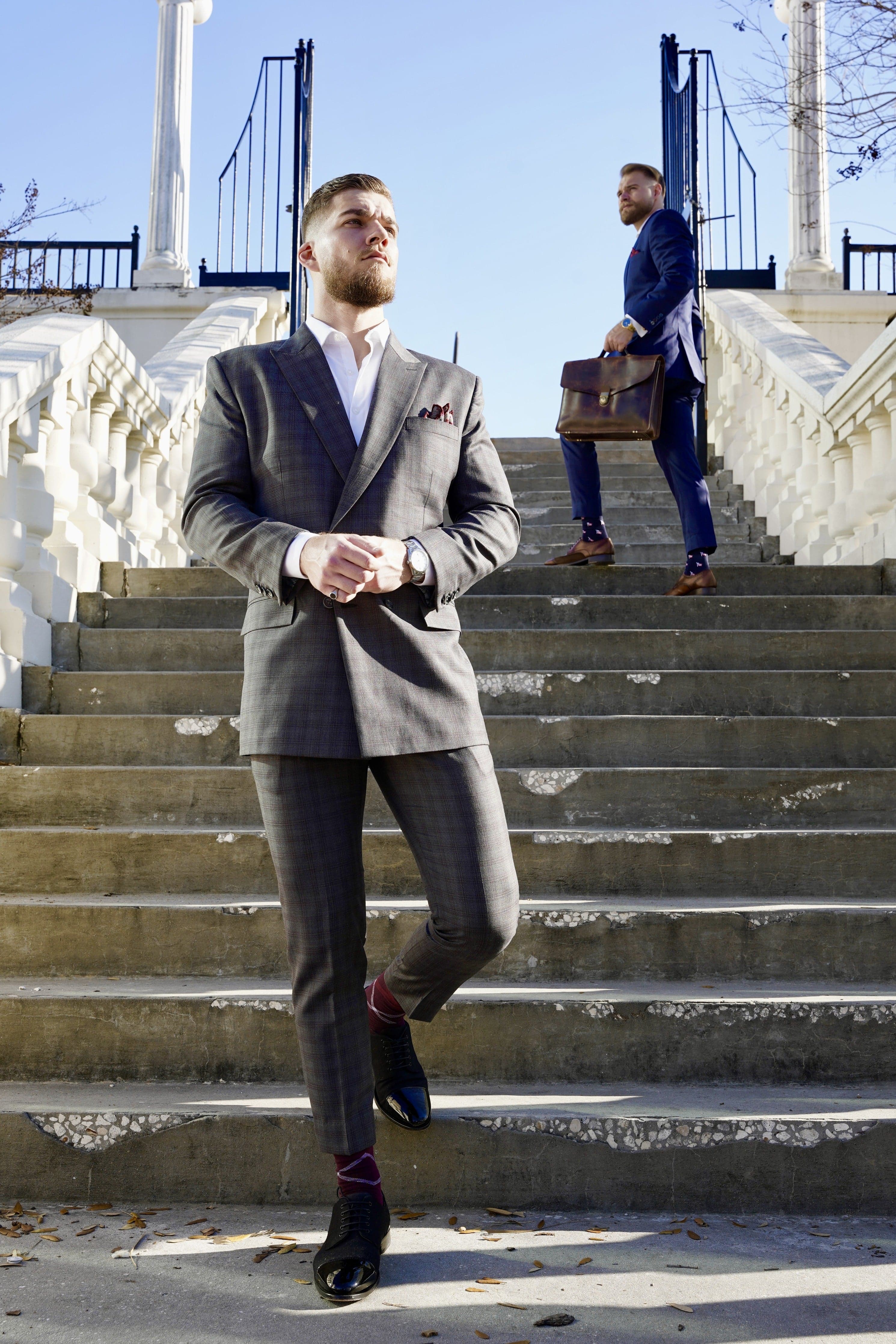 Two men in tailored suits on a stone staircase